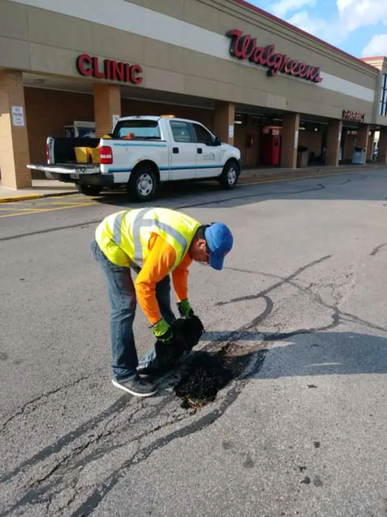 Asphalt pot hole repair in a commercial parking lot